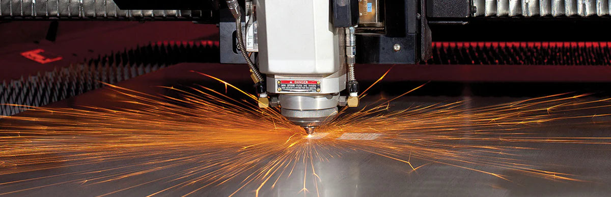 OP Machine and Fabrication Amada Ensis 3015 laser cutting machine action shot throwing sparks on initial pierce
