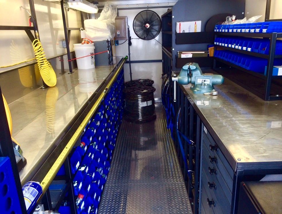 OP Machine and Fabrication workshop interior with blue shelving units and tools