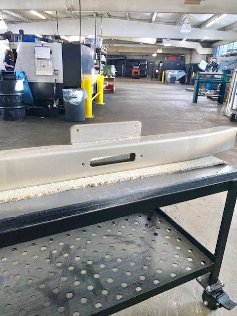 OP Machine and Fabrication custom metal component on industrial workbench
